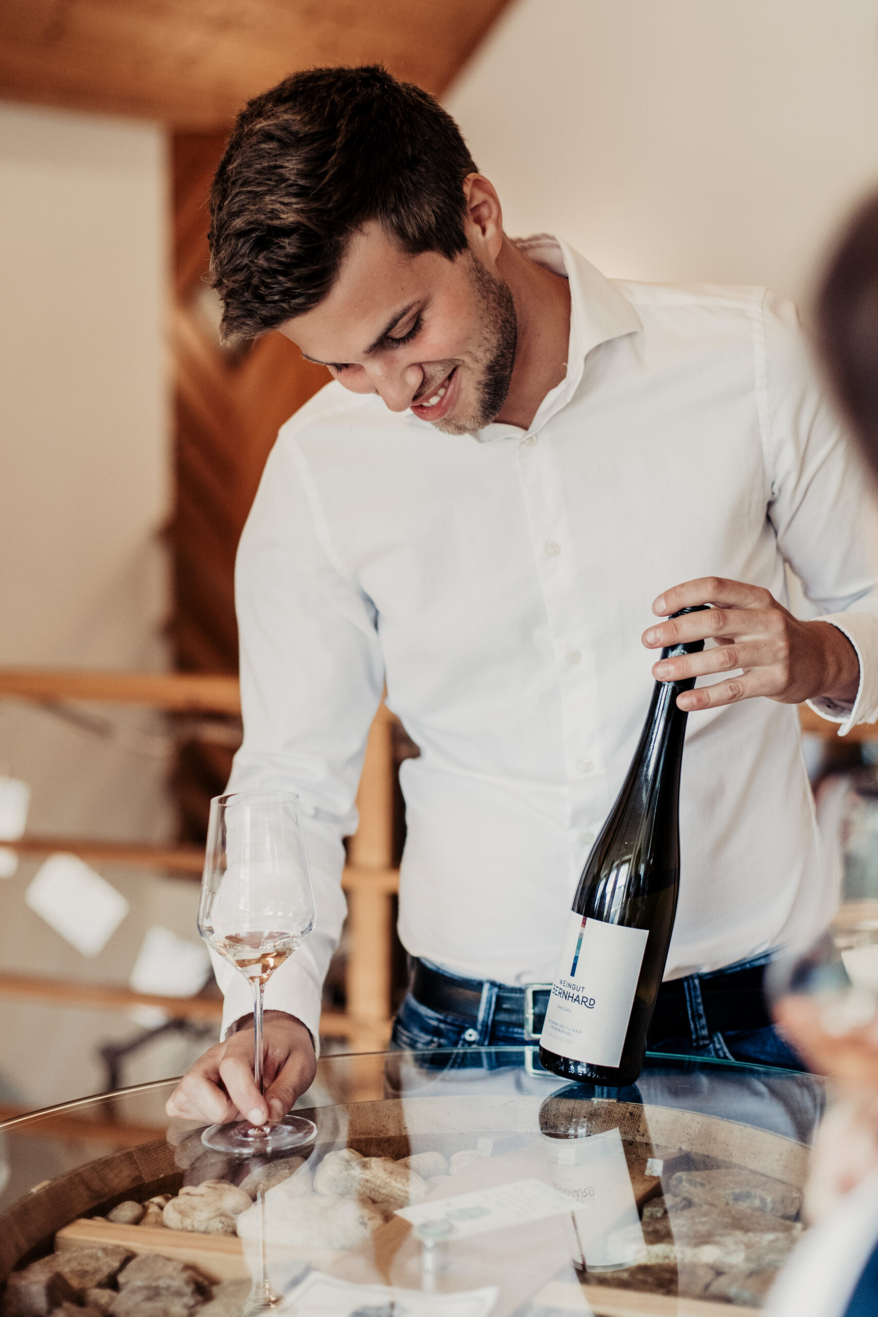 Christoph Bernhard hebt eine Weinflasche in die Höhe
