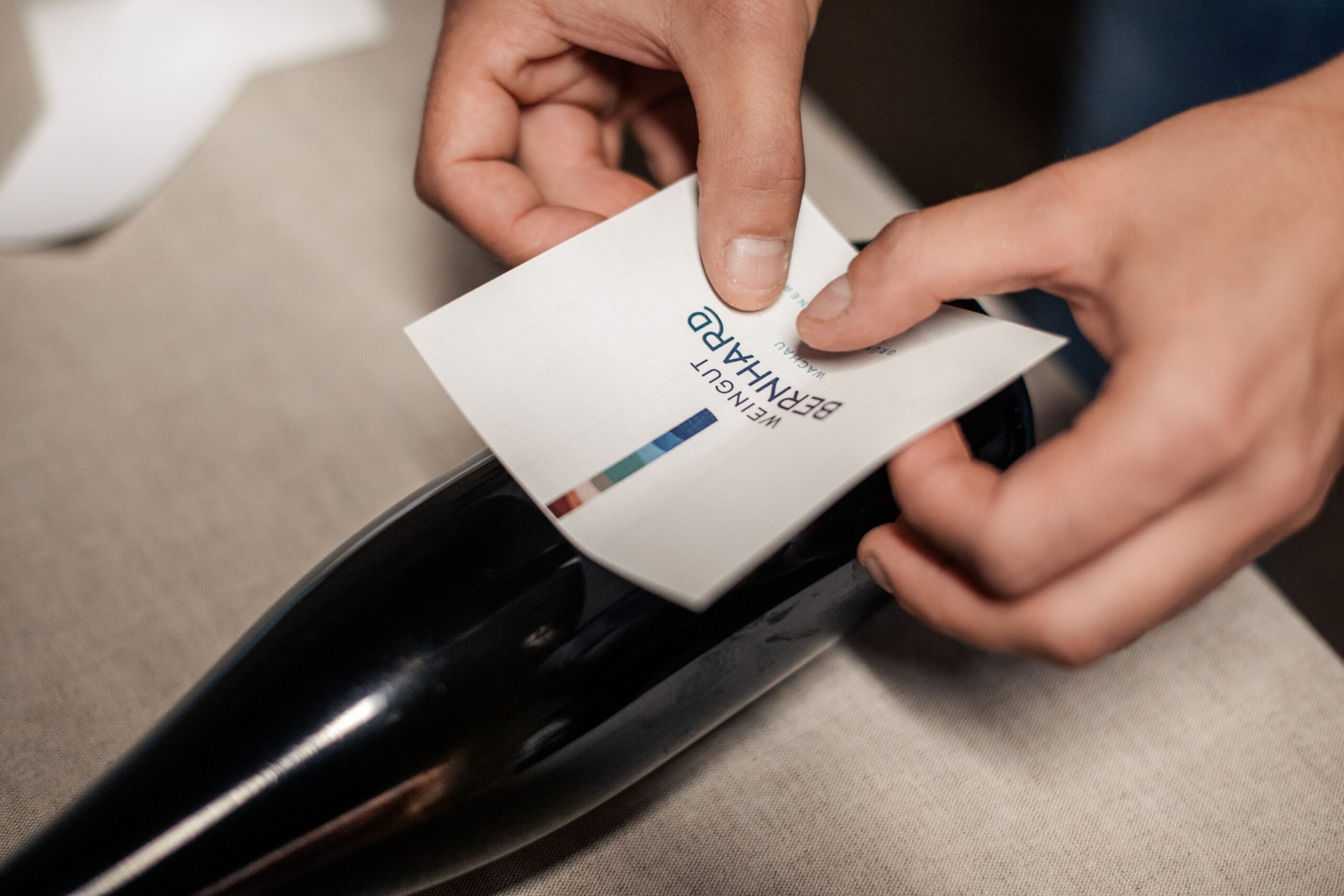 Ein Etikett wird auf eine Weinflasche geklebt