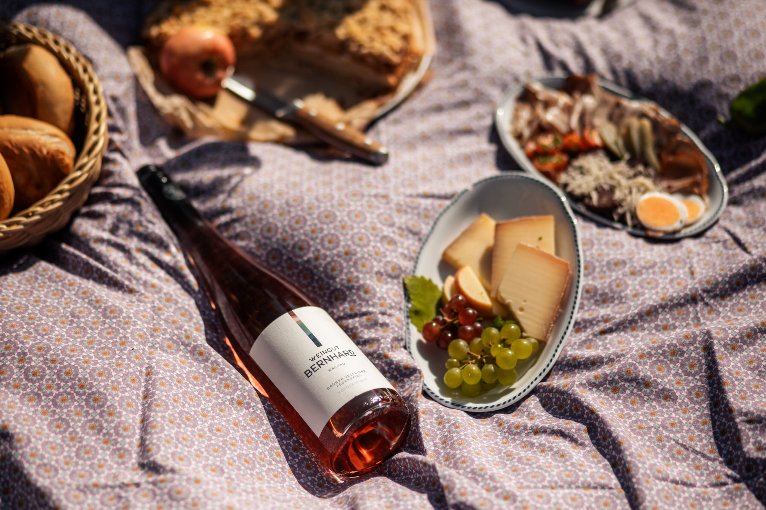 Picknickdecke mit regionalen Köstlichkeiten und einer Flasche Wein