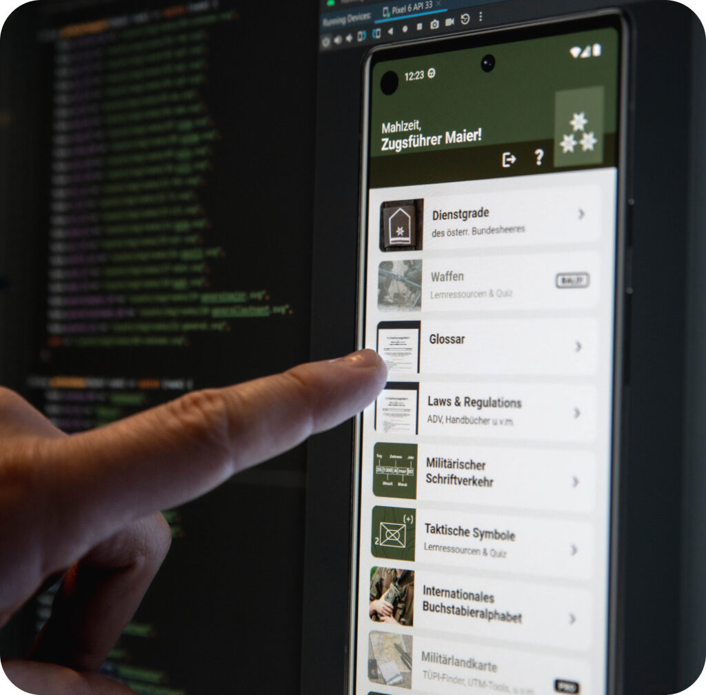 Ein Finger zeigt auf den Bildschirm, auf dem eine App-Entwicklung stattfindet
