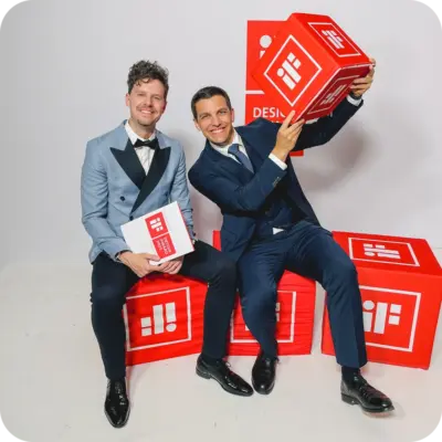 Philipp Pieh-Sandpeck und Lukas Kränkl sitzen auf roten Würfeln beim IF Design Award